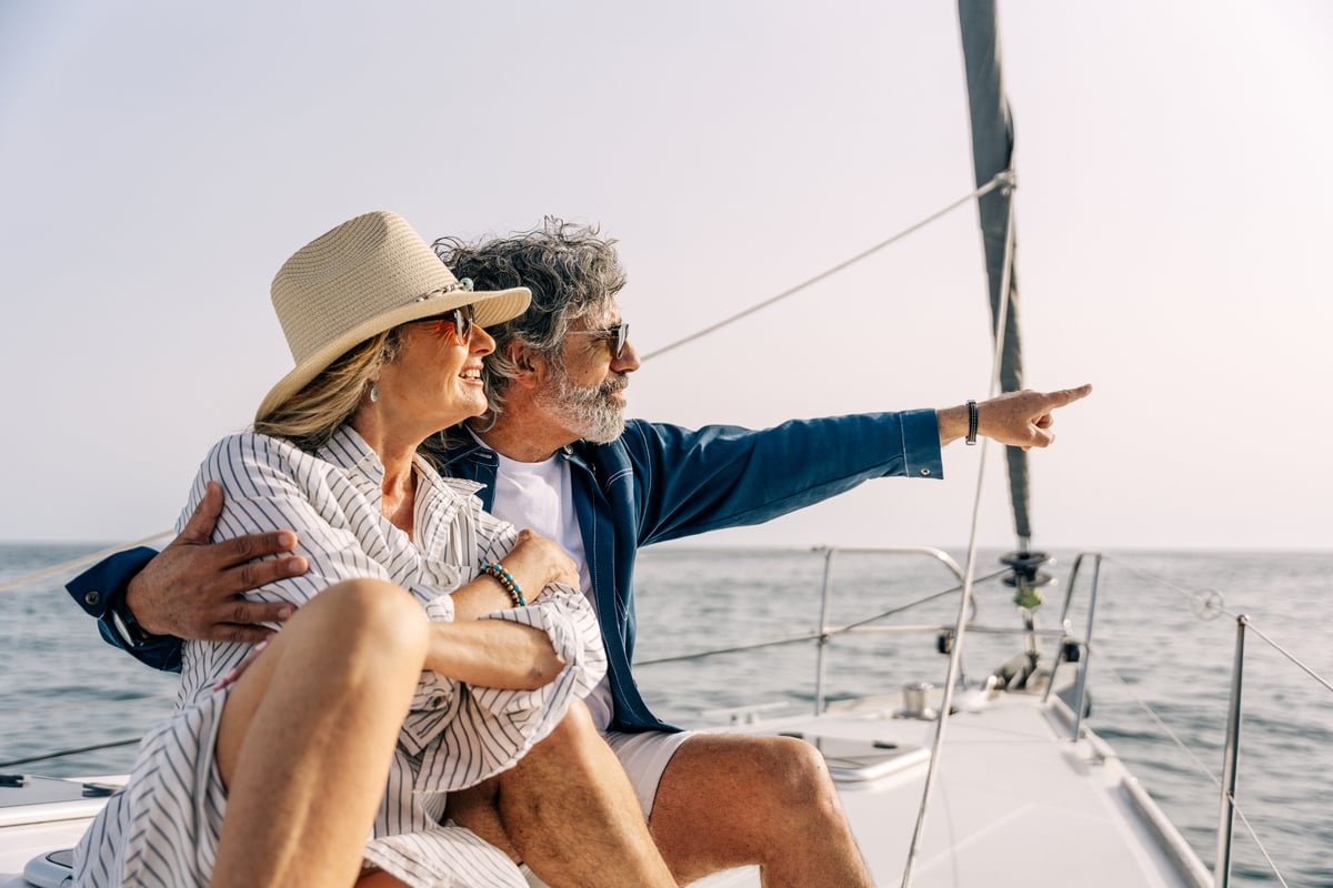 Pareja de adultos mayores disfrutando en un velero